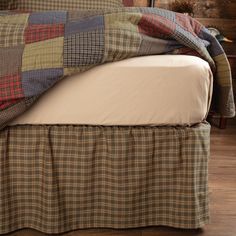 a bed with a plaid bedspread on top of it