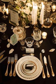 the table is set with silverware, candles and napkins for an elegant dinner