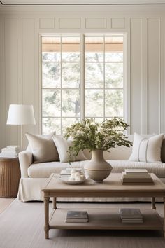 a living room filled with furniture and a window covered in white curtains next to a coffee table