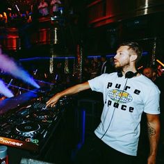 a man standing in front of a dj's mixer