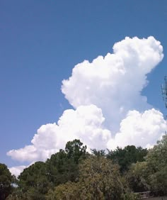 the sky is filled with clouds and trees