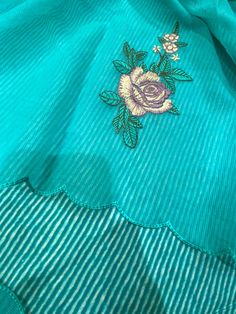 a blue shirt with flowers embroidered on it