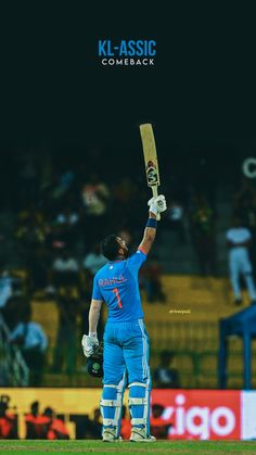 a cricket player holding his bat up in the air while standing on top of a field