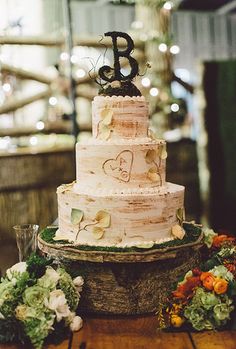 a three tiered wedding cake sitting on top of a wooden table