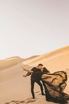 a man and woman are dancing in the desert