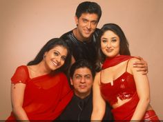 two men and three women posing for a photo together in red dresses with their arms around each other