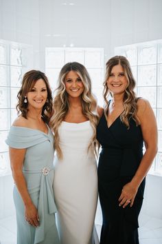 three beautiful women standing next to each other