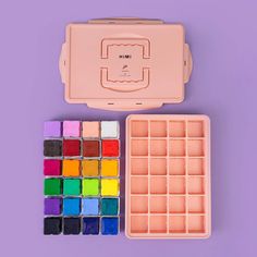 a pink box with lots of different colored paint in it next to an ice tray