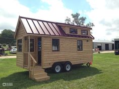 a tiny house on wheels is parked in the grass