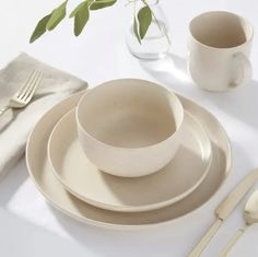 a table set with plates, cups and utensils