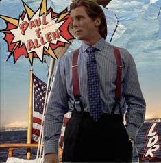 a man wearing suspenders and a tie standing in front of a poster with an american flag