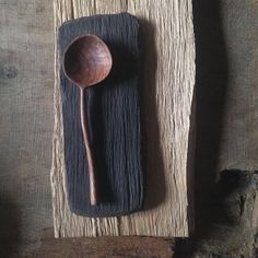 a wooden spoon sitting on top of a piece of wood