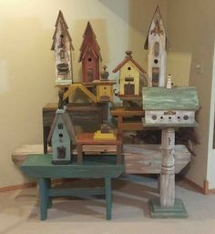 several birdhouses are stacked on top of each other in a room with white walls