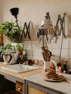 a kitchen counter with utensils hanging on the wall