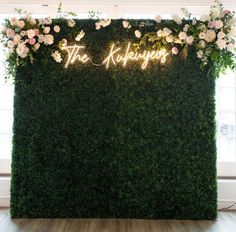 the reception sign is lit up with flowers and greenery as well as neon lights