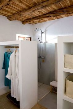 a bathroom with white walls and wooden ceiling