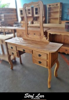 a wooden desk with a mirror on top of it in a room filled with furniture