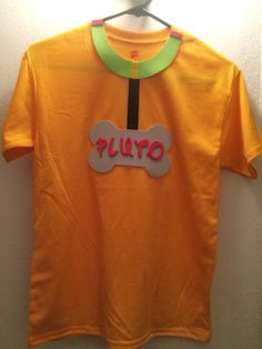 an orange shirt with a dog bone on it that says puyo hanging from a hanger