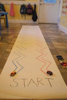 a child's play area with cars on the floor and a sign that says start