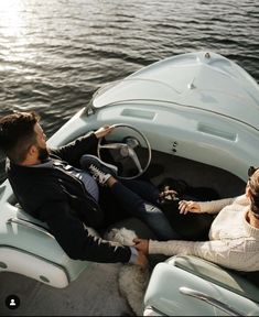 a man and woman sitting in a boat on the water