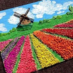 a multicolored rug with a windmill in the middle and flowers all over it