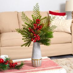 a living room filled with furniture and a christmas tree in a vase on top of a coffee table