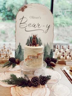 there is a cake on the table with pine cones and other decorations around it that says beaver's bear - y