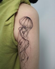 a woman's arm with a black ink drawing of a jellyfish