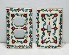 two decorative light switch plates with flowers and leaves painted on the sides, one has a single outlet