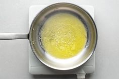 a pan filled with yellow liquid on top of a stove