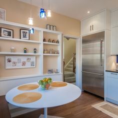 a kitchen with white cabinets and blue back splash on the countertop, along with a stainless steel refrigerator