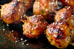 chicken skewers with sesame seeds and seasoning sprinkled on the side