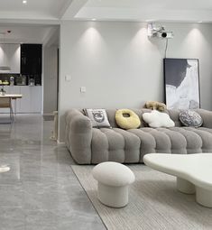 a living room filled with furniture next to a kitchen