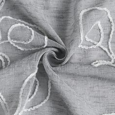 a close up view of the fabric with white stitching on it and an embroidered design