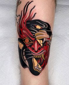 a tattoo on the leg of a man with an animal head and demon's face