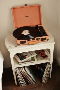 an old record player sitting on top of a white table