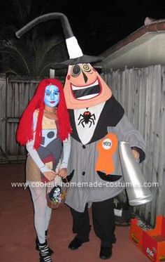 two people dressed in costumes standing next to each other near a fence at night time