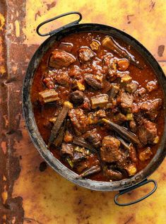 a pot filled with meat and vegetables on top of a table