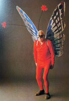 a man dressed in an orange outfit and butterfly wings