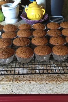 muffins cooling on a wire rack in the middle of a kitchen counter top