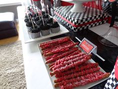 red and black desserts are displayed on trays in front of a cake stand