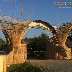 an arch made out of bamboo sticks in front of a building