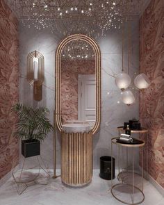 a bathroom decorated in gold and marble with an oval mirror above the sink, two planters on either side