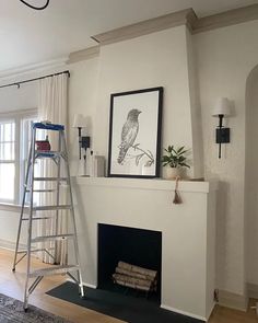 a living room with a fire place and a ladder in front of the fireplace that is painted white