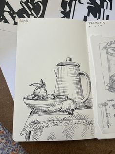 an open book with drawings on it and some papers next to it that have pictures of food in them