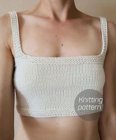 a close up of a woman wearing a white knitted crop top with crochet