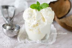 an ice cream sundae with mint garnish and spoons on the side