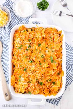 a casserole dish with cheese and parsley in it on a blue towel