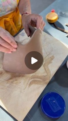 a woman is making clay sculptures on a table