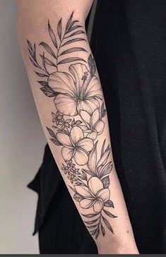 a woman's arm with flowers and leaves tattooed on the side of her arm